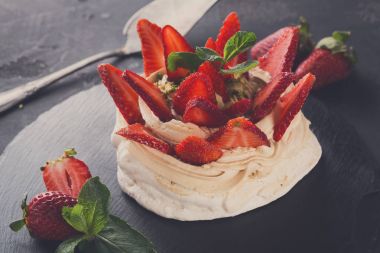 Anna Pavlova pasta siyah arka plan üzerine çilek ile