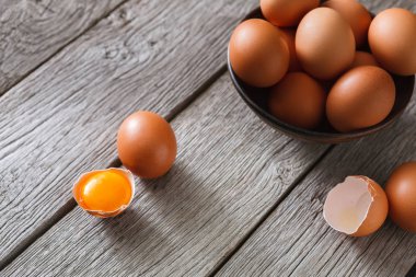 Siyah arka plan, ahşap üzerine kase taze kahverengi yumurta