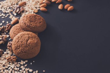 Düz yatıyordu yulaf kurabiye ve koyu arka plan üzerinde fındık