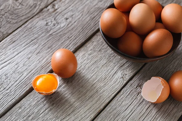Siyah arka plan, ahşap üzerine kase taze kahverengi yumurta