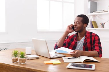 Genç siyah işadamı modern beyaz Office belgeleri okuyun