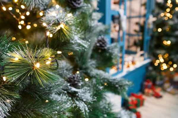 Украшенные рождественские елки на блестящем фоне гирлянды — стоковое фото