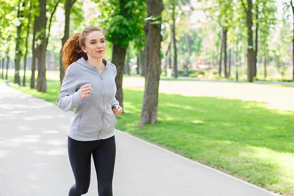 Mujer joven corriendo en el parque verde, espacio para copiar —  Fotos de Stock