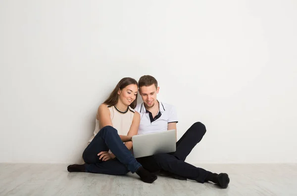Glada par använder laptop hemma, kopiera utrymme — Stockfoto