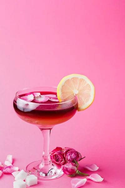 Roze cocktail in champagne glas op roze achtergrond — Stockfoto