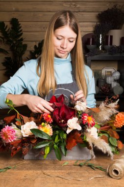 Genç kadın renkli sonbahar buket çiçek dükkanında oluşturma