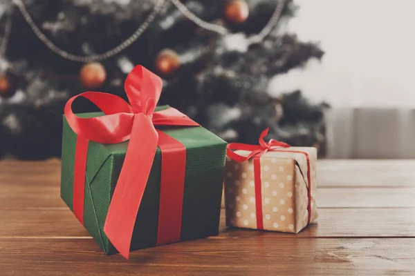 Vánoční dárky na nazdobený stromeček pozadí, dovolená concept — Stock fotografie