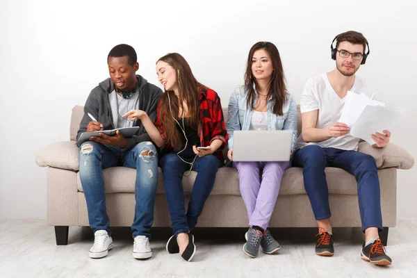 Jovens pessoas diversas ouvem música com gadgets — Fotografia de Stock