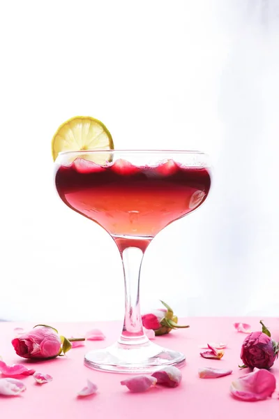 Roze cocktail in champagne glas op roze achtergrond — Stockfoto