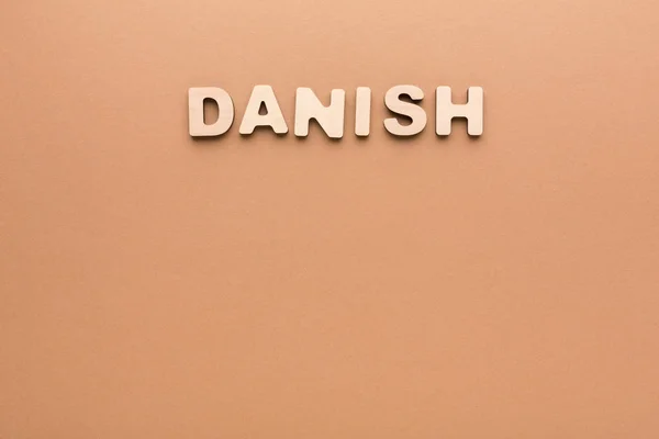 Ordet dansk på beige baggrund - Stock-foto