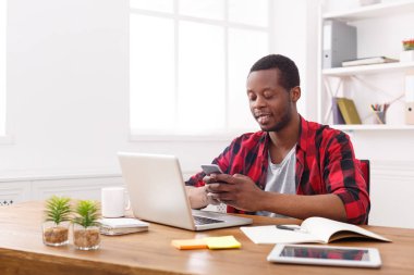 Modern beyaz ofis içinde hareket eden telefon ile genç siyah işadamı