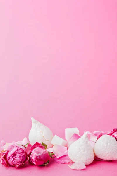 Merengues blancos y brotes de rosas en el fondo rosa —  Fotos de Stock