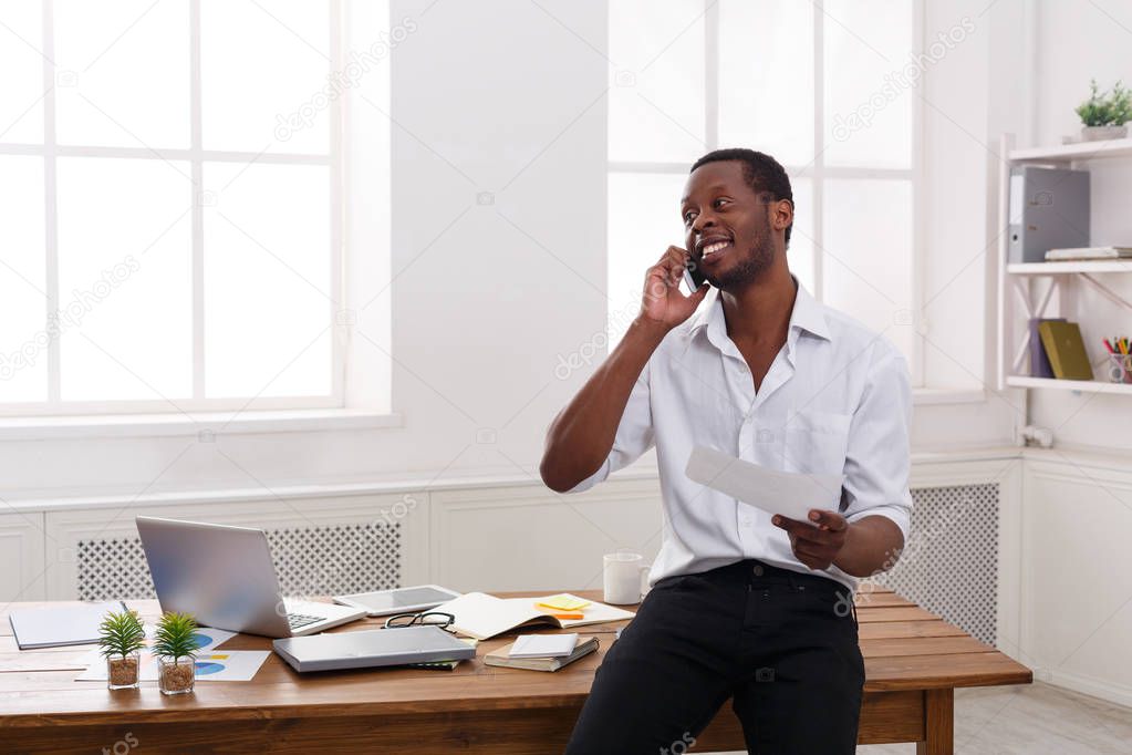 Young black businessman read documents in modern white office