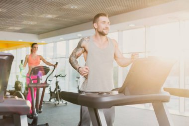 Koşu bandında koşmak spor salonunda genç adam