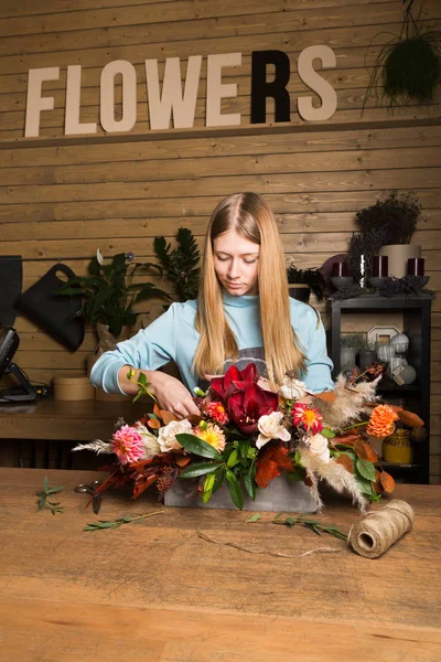 Mujer joven creando colorido ramo de otoño en la tienda de flores —  Fotos de Stock