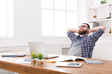 Genç işadamı modern beyaz ofis içinde laptop ile rahat