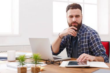 Oturma ve tablet bilgisayar kullanma office ciddi bir genç işadamı portresi kapatın