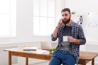 Kahve içme ve cep telefonu Office konuşurken yakışıklı işadamı