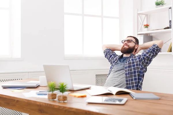 Молодой расслабленный бизнесмен с ноутбуком в современном белом офисе — стоковое фото