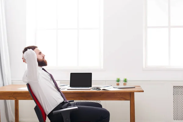 Jonge ontspannen zakenman in wit overhemd met laptop in moderne witte kantoor — Stockfoto