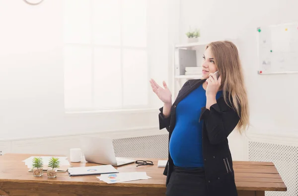 Mujer de negocios embarazada hablando por teléfono en la oficina — Foto de Stock