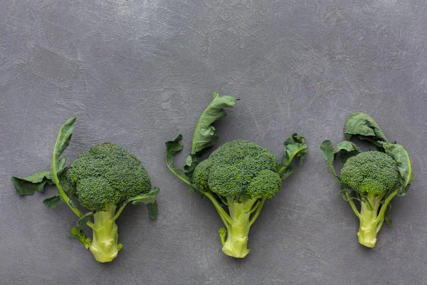 Świeże zielone brokuły na szarym tle, kopiować przestrzeń, widok z góry — Zdjęcie stockowe