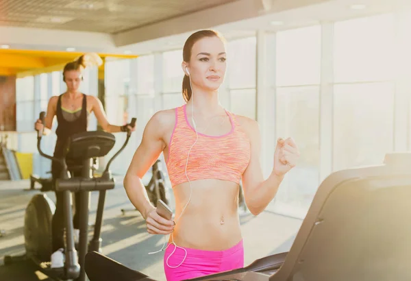 Young woman in gym run on treadmill — Stock Photo, Image