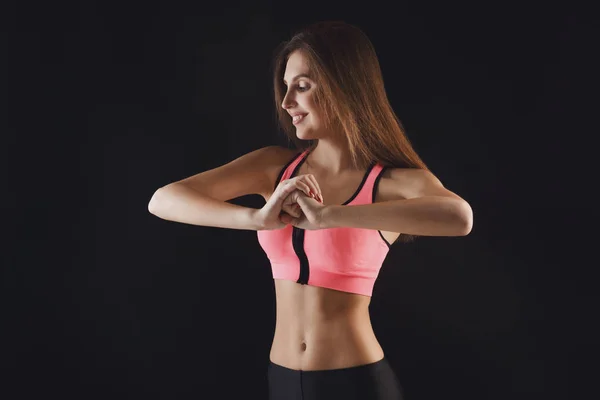 Hermosa chica de fitness posando sobre fondo negro — Foto de Stock