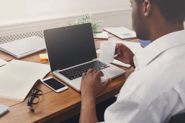 Afro-Amerikaanse zakenman in kantoormachines op laptop — Stockfoto