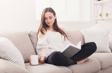 Günlüğü ile kanepede oturan genç kadın