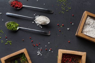 Kaşık ve koyu arka planda, üstten görünüm, ahşap kutular içinde çeşitli baharatlar alanı Kopyala