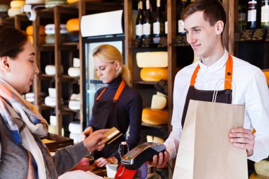 Bakkal dükkanı beyaz peynir sırasını için ödeme müşteri.