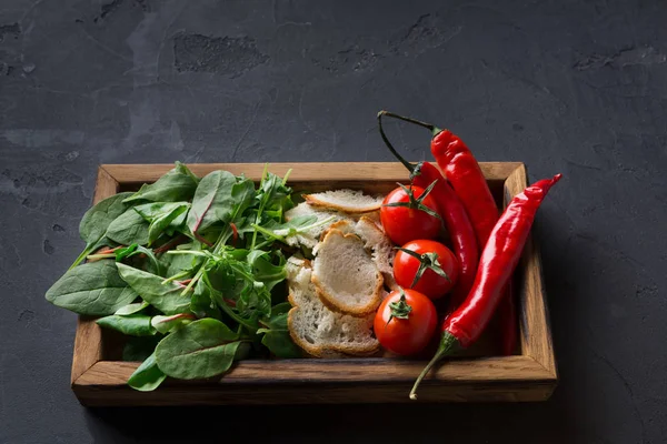 Cooking ingredients in wooden box on dark background — Stock Photo, Image