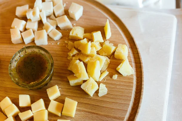 Prato de queijo, parmesão em prato de madeira natural com molho — Fotografia de Stock