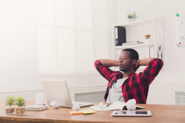 Genç işadamı modern beyaz ofis içinde laptop ile rahat