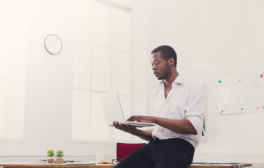 Geçici ofis, konsantre siyah işadamı lapto ile çalışmak