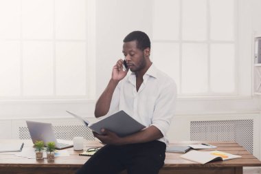 Genç işadamı okuma belgeleri siyah ve mobil mod konuşmak