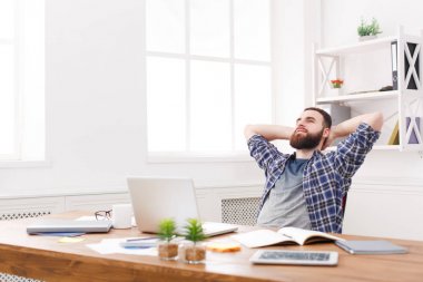 Modern beyaz ofis içinde laptop ile kendine güvenen genç işadamı
