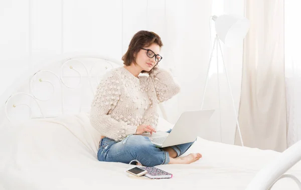 Молодая женщина фрилансер с ноутбуком в постели — стоковое фото