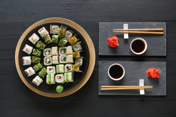 Set sushi maki en broodjes op zwarte rustieke houten, top uitzicht — Stockfoto