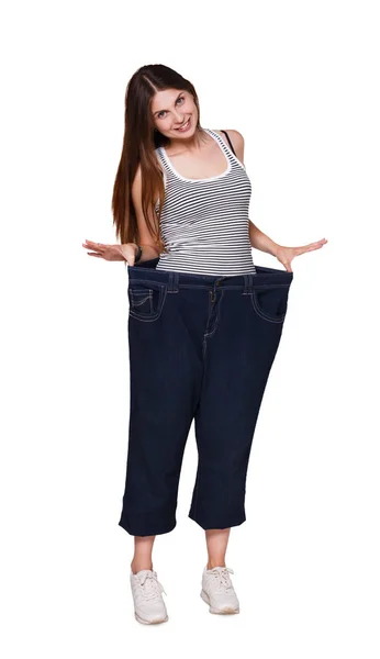 Kobieta nosi dżinsy znacznie większy rozmiar na białym tle na białym tle. — Zdjęcie stockowe