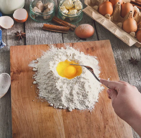 Kadın baker yumurta, tereyağı ve un ile hamur yapar