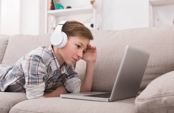 Tonårspojke njuter av musik i hörlurar hemma — Stockfoto