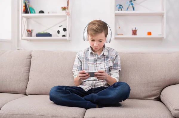 Casual adolescente jugando juego móvil en casa — Foto de Stock