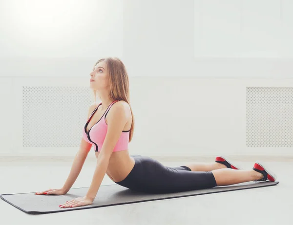 Fitness vrouw terug uitrekkende training binnenshuis — Stockfoto