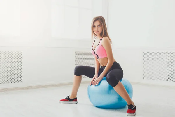 Νεαρή γυναίκα να κάνει ασκήσεις γυμναστικής με ταιριάζει μπάλα — Φωτογραφία Αρχείου