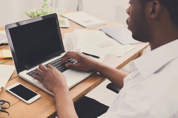 Afro-Amerikaanse zakenman in kantoormachines op laptop — Stockfoto