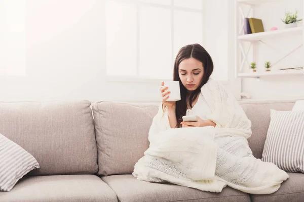 Acogedora casa. Chica en un cuadros con móvil — Foto de Stock