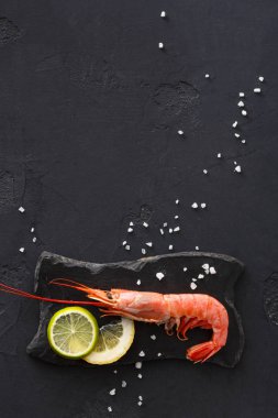 Siyah arka plan üzerine limon ve tuz ile karides