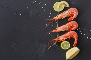 Siyah arka plan üzerine limon ve tuz ile karides